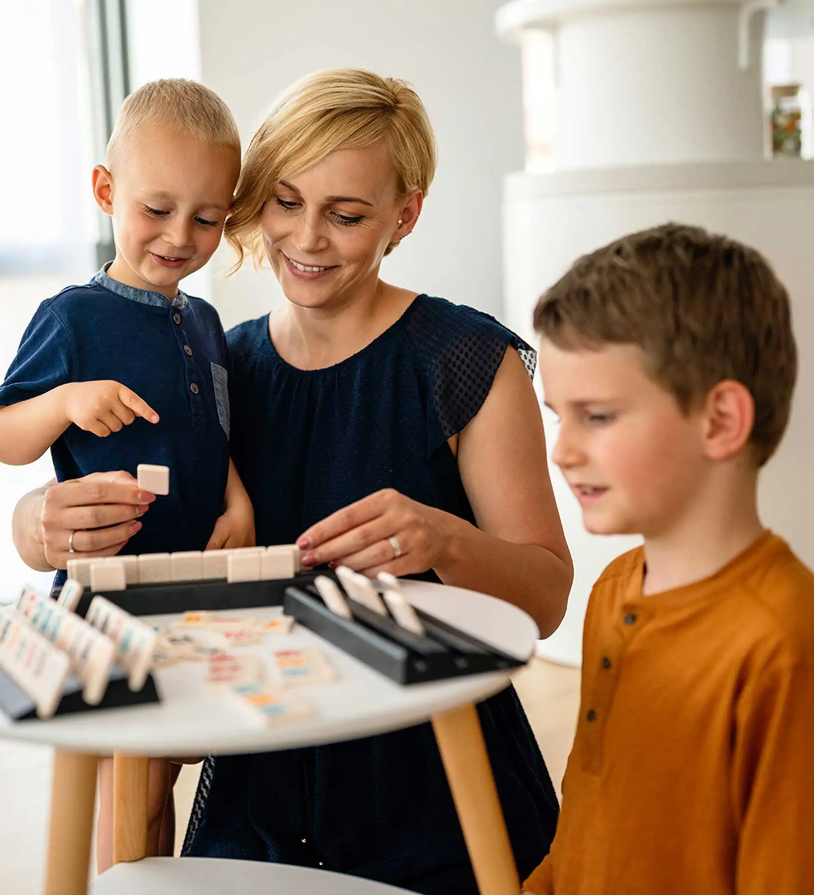Therapist engaging in children's play therapy with two kids using games.